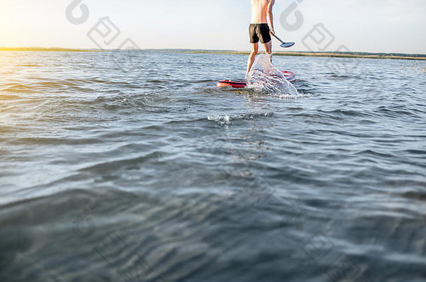 男人。paddleboarding湖