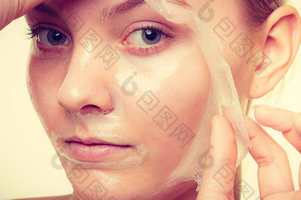 美容护肤化妆品与健康理念。年轻女子面部，女孩卸除面膜。剥皮。