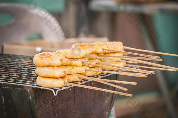 涂有蛋黄的吐司糯米，粘在烤架上。这是泰国北部的传统小吃，味道又甜又咸。