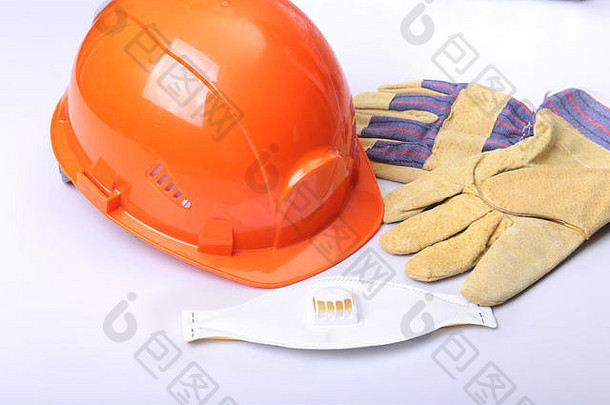 白色背景上的橙色安全帽、护目镜、防护面罩、呼吸器和安全手套。