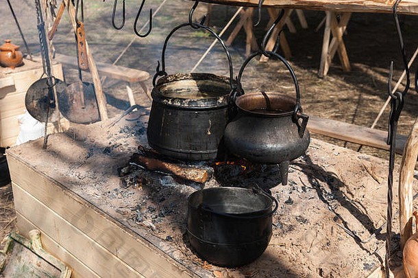 黑色的坩埚挂钩子开放火中世纪的营烹饪晚餐高贵的骑士
