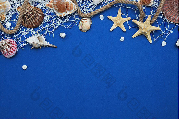 蓝色背景下的海星、贝壳、石头、绳子和网。夏季冬日。航海概念
