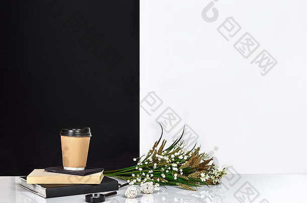 花，书，笔记本和咖啡，黑白墙。