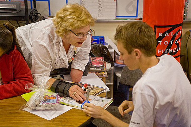一位受过专门培训的中年教师本人是残疾人，在加州一所学校与残疾学生一起工作