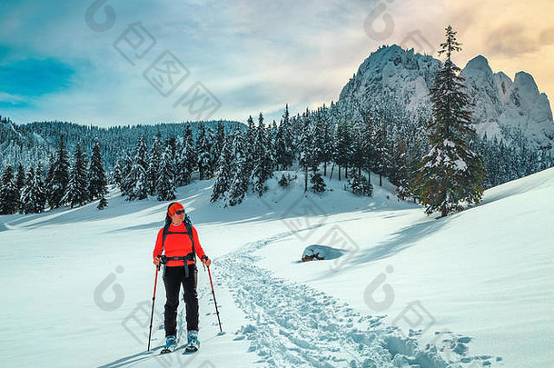 快乐背包客女人新鲜的粉雪滑雪巡回演出雪山边远地区滑雪女人色彩斑斓的背包山设备