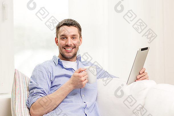 微笑的男人在家里使用平板电脑