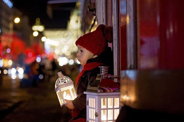 圣诞夜，布拉格，一个可爱的蹒跚学步的小男孩手里拿着灯笼和一只泰迪熊