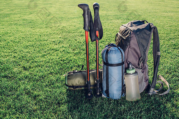 背包，登山杖，绿草上的睡袋