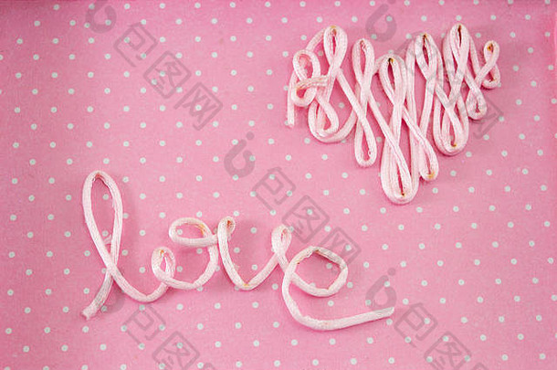 “爱”这个词是用粉色背景上的线做成的