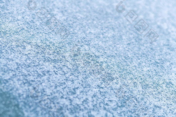 积雪覆盖的车窗，微距，特写。没有使用防冻剂。雪地里的车辆。冬天快到了。恶劣的天气条件