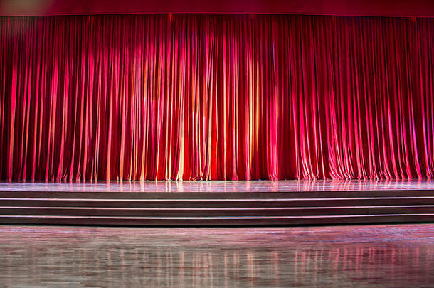 剧院里的红色窗帘和带楼梯的舞台拼花地板，五颜六色的灯光。