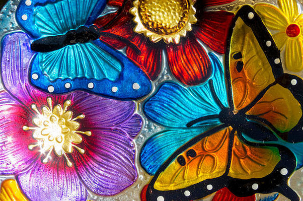 色彩鲜艳的彩绘玻璃的抽象背景，上面有花朵和蝴蝶