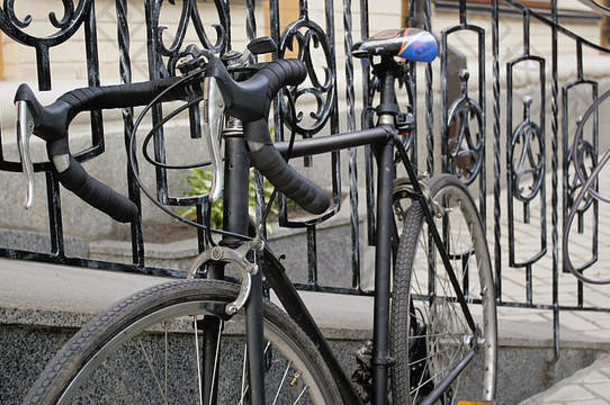 复古黑色自行车锁在金属门上的特写照片