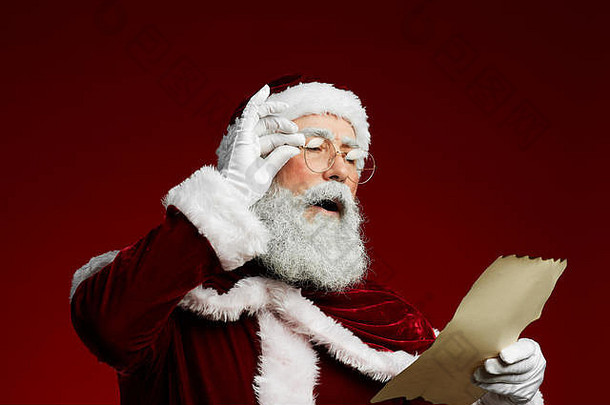 腰肖像经典圣诞老人阅读列表羊皮纸站红色的背景复制空间