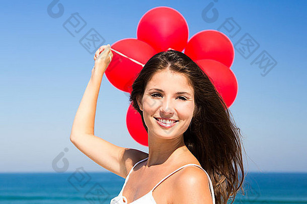美丽的女孩红色的气球海滩