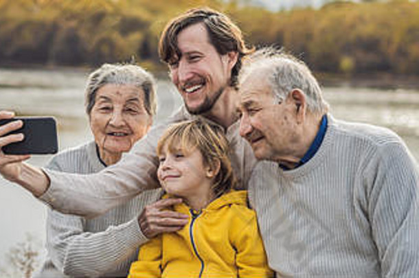 班纳，长格式高级夫妇与孙子和曾孙在秋季公园自拍。曾祖母、曾祖父和