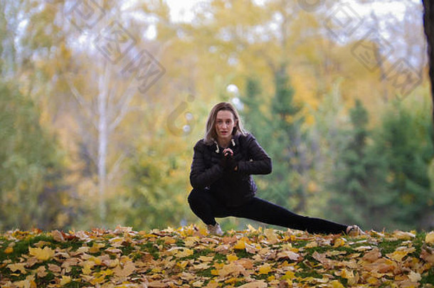 女孩体操运动员伸展运动腿秋天公园