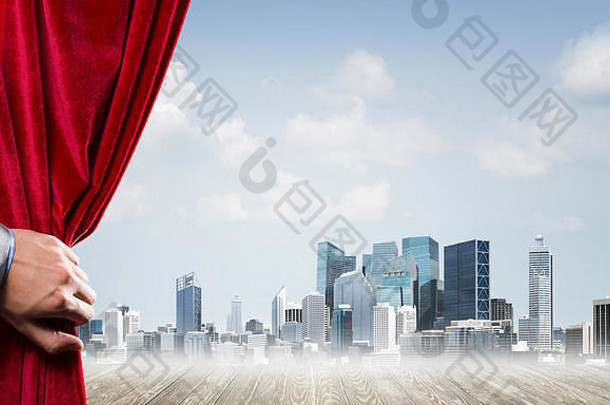 商业城在灰色的雾霭中，身后是红色的窗帘，手里握着它