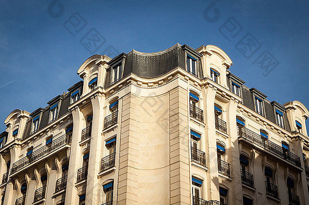 巴黎一座多层历史联排别墅的外部，装饰华丽的石头立面，高高的窗户和一个可以看到的拱顶