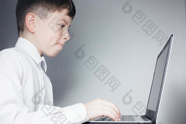 学龄儿童在灰色背景下看电脑