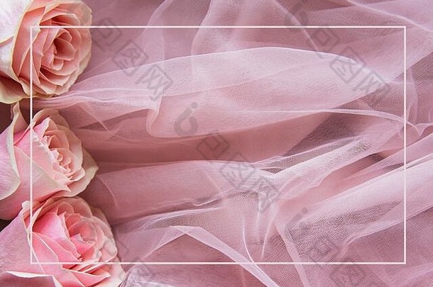 粉红色的玫瑰作为一个粉红色薄纱的边界，平放。