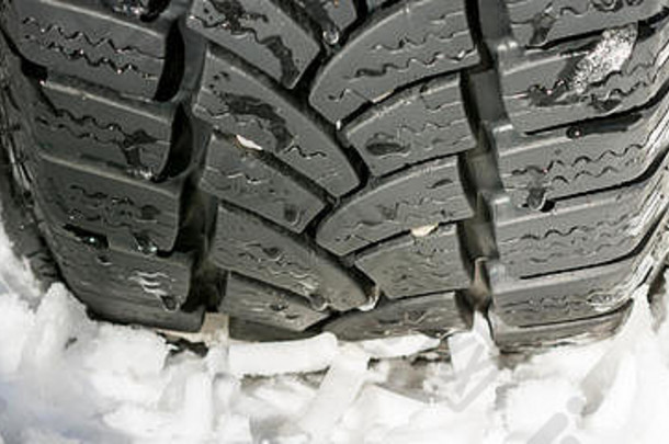汽车轮胎在雪地上行驶。冬季驾驶条件。