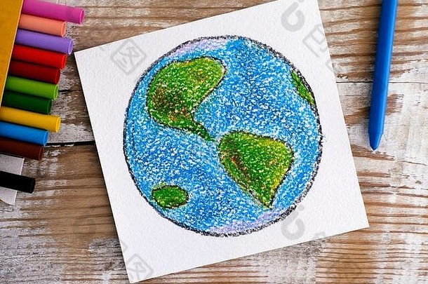 在木制背景上用蜡笔手工绘制地球。