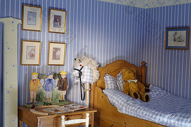 蓝色的白色条纹壁纸蓝色的检查羽绒被松床上孩子的卧室小桌子上椅子