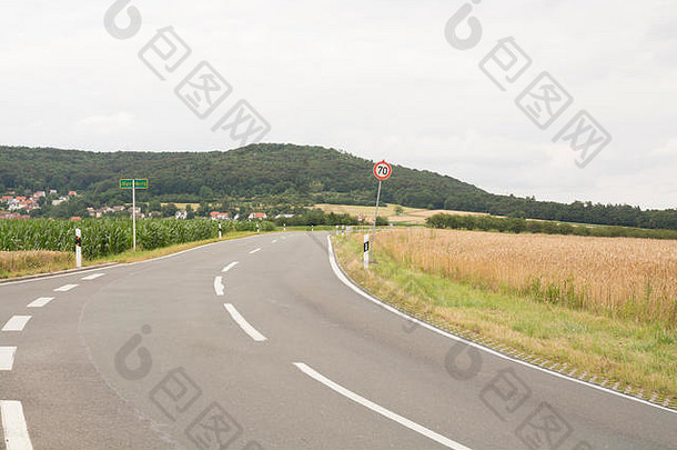 德国巴伐利亚州麦田沿线的道路——青山、金色麦田和干净的道路。德国巴伐利亚州的麦田——黄金时代来临