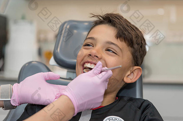 牙医检查口腔时小男孩张大嘴巴的画像。