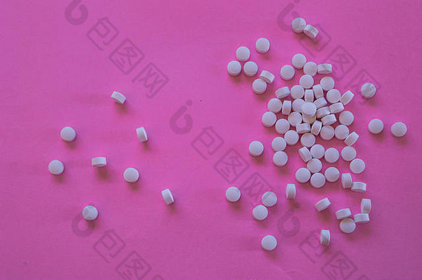 大量白色药片分散粉红色的背景空间添加元素色彩斑斓的流行摄影概念医学人类健康