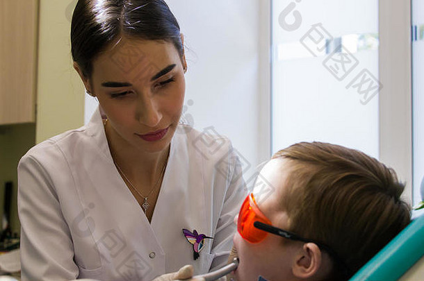 接待牙科年轻的女牙医检查口服腔孩子
