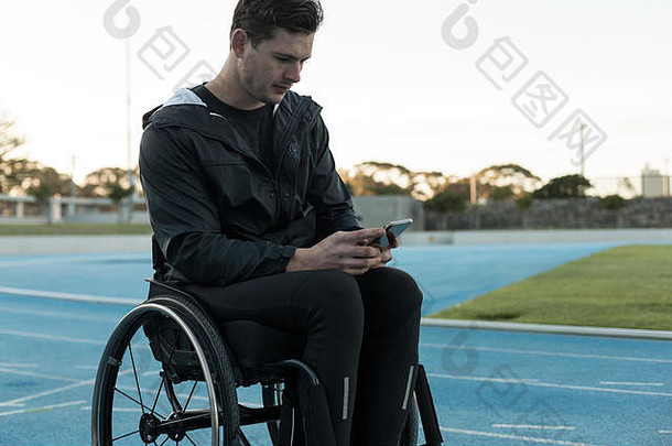 残疾人运动员在运动场使用手机