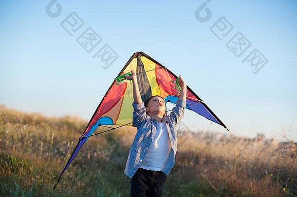 快乐的小男孩，手里拿着五颜六色的风筝，抬头仰望