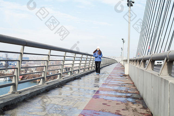 女人跑步者慢跑城市桥冬天季节