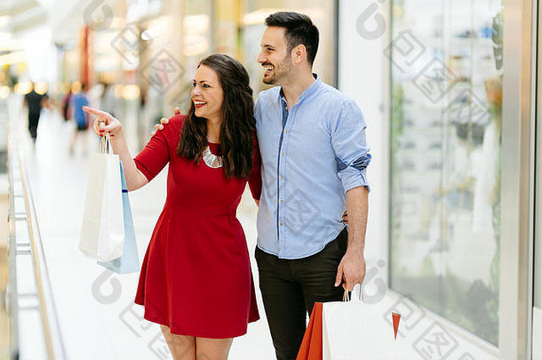 快乐购物夫妇在购物中心买衣服