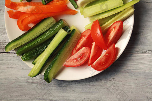 白色板蔬菜素食者沙拉萝卜西红柿芹菜贝尔胡椒洋葱黄瓜白色木厨房表格关闭