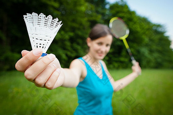 漂亮的年轻的女人玩羽毛球城市公园可爱的夏天一天浅景深