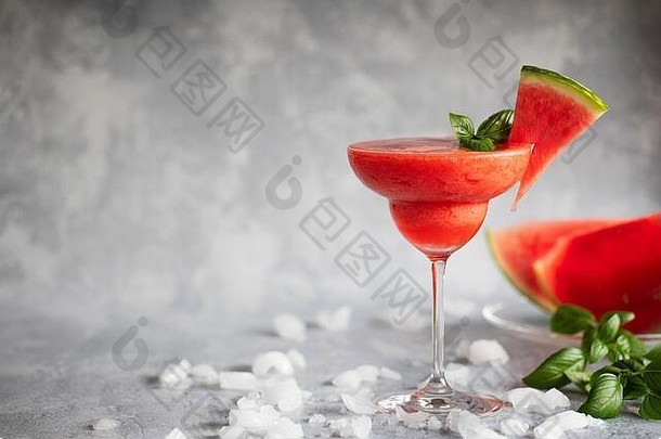 一种新鲜冷冻的混合了草莓和西瓜的玛格丽塔酒。这种饮料用罗勒叶和西瓜装饰。冰上散落的草