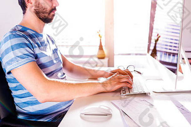 坐在<strong>办公</strong>桌旁用电脑<strong>在家工作的</strong>男人