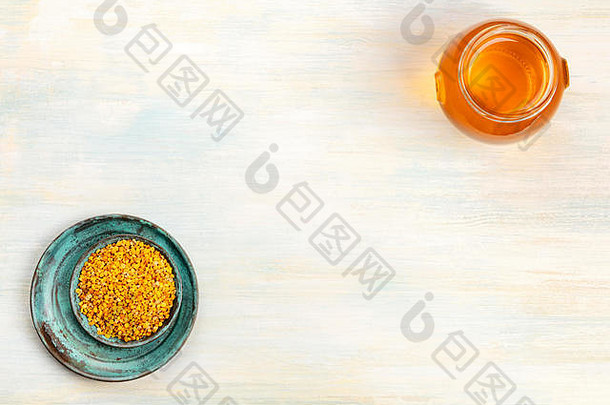 健康的有机食品。一张头顶上的花粉和一罐蜂蜜的照片，从上方拍摄，背景光线明亮，有复印空间