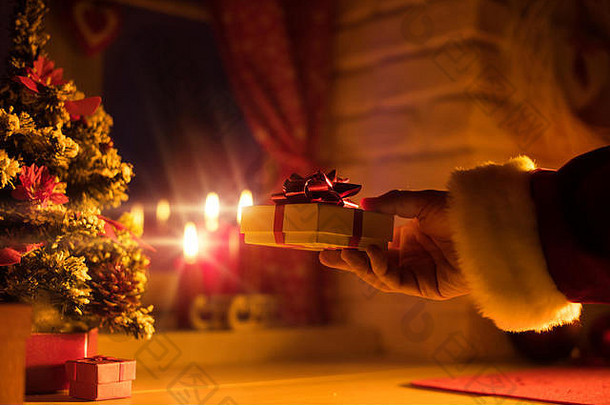 圣诞老人老人把美丽的礼物圣诞节夏娃的晚上手关闭基斯蜡烛背景