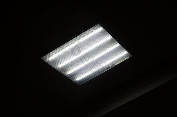 黑暗中天花板上的方形荧光灯