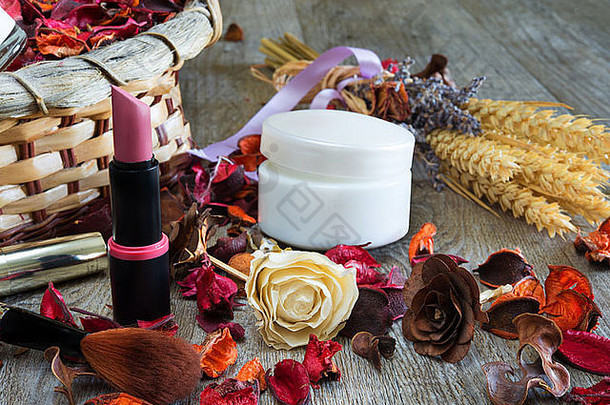 木制桌子，配有化妆用品和干燥的芳香花朵