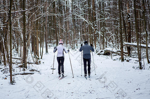图像回来体育女人男人。滑雪冬天森林