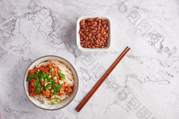 白色大理石桌面上的花生面和筷子。缅甸菜传统菜肴。缅甸食品。番茄猪肉米粉