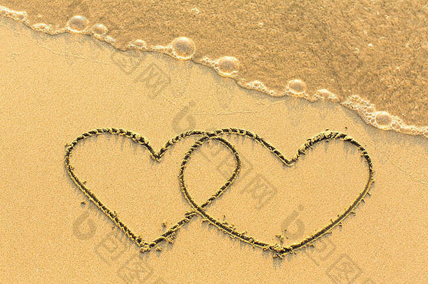 一对在<strong>金色</strong>沙滩上手工绘制的心。