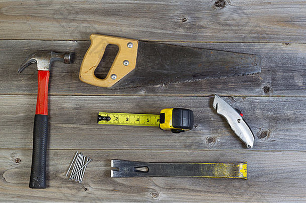 基本家用维修工具俯视图，包括锯木、锤子、钉子、切盒机、撬杆和粗木卷尺