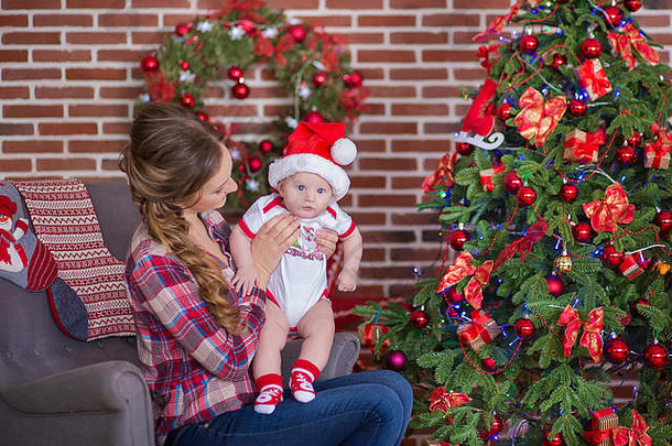 妈妈妈妈带着一个可爱漂亮的小女儿，坐在圣诞树旁玩耍、<strong>咕咕叫</strong>。