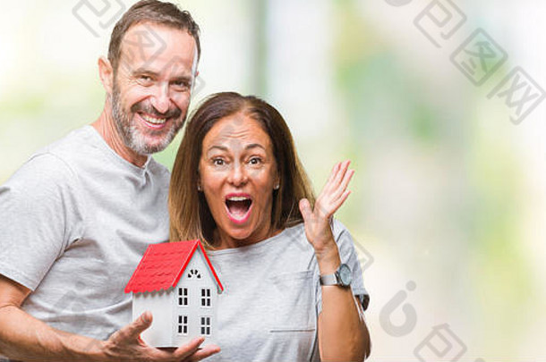 中间年龄拉美裔休闲夫妇购买房子孤立的背景快乐兴奋赢家表达式庆祝胜利尖叫